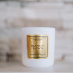 White candle with a gold label on a blurred background