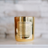 Gold candle with a label on a white surface