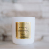 White candle with a gold label on a blurred background
