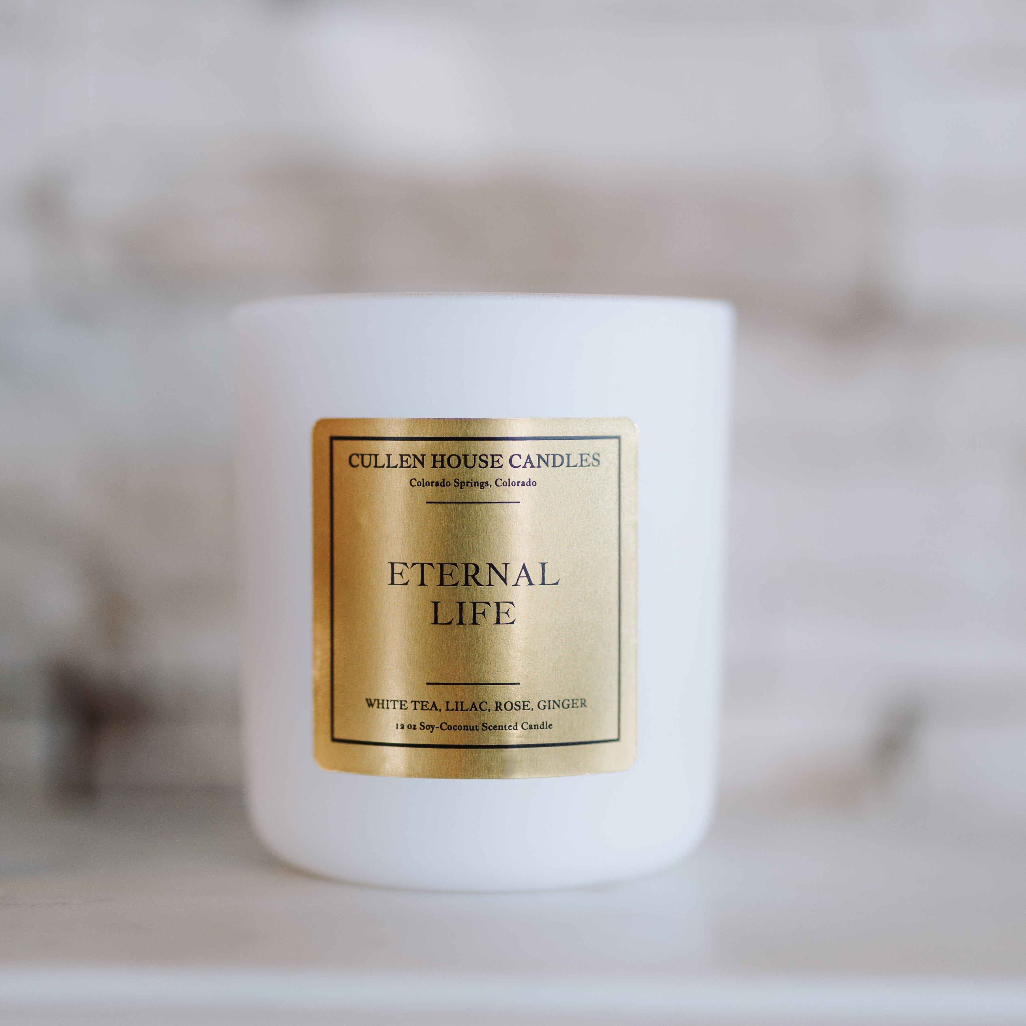 White candle with 'Eternal Life' label on a blurred background
