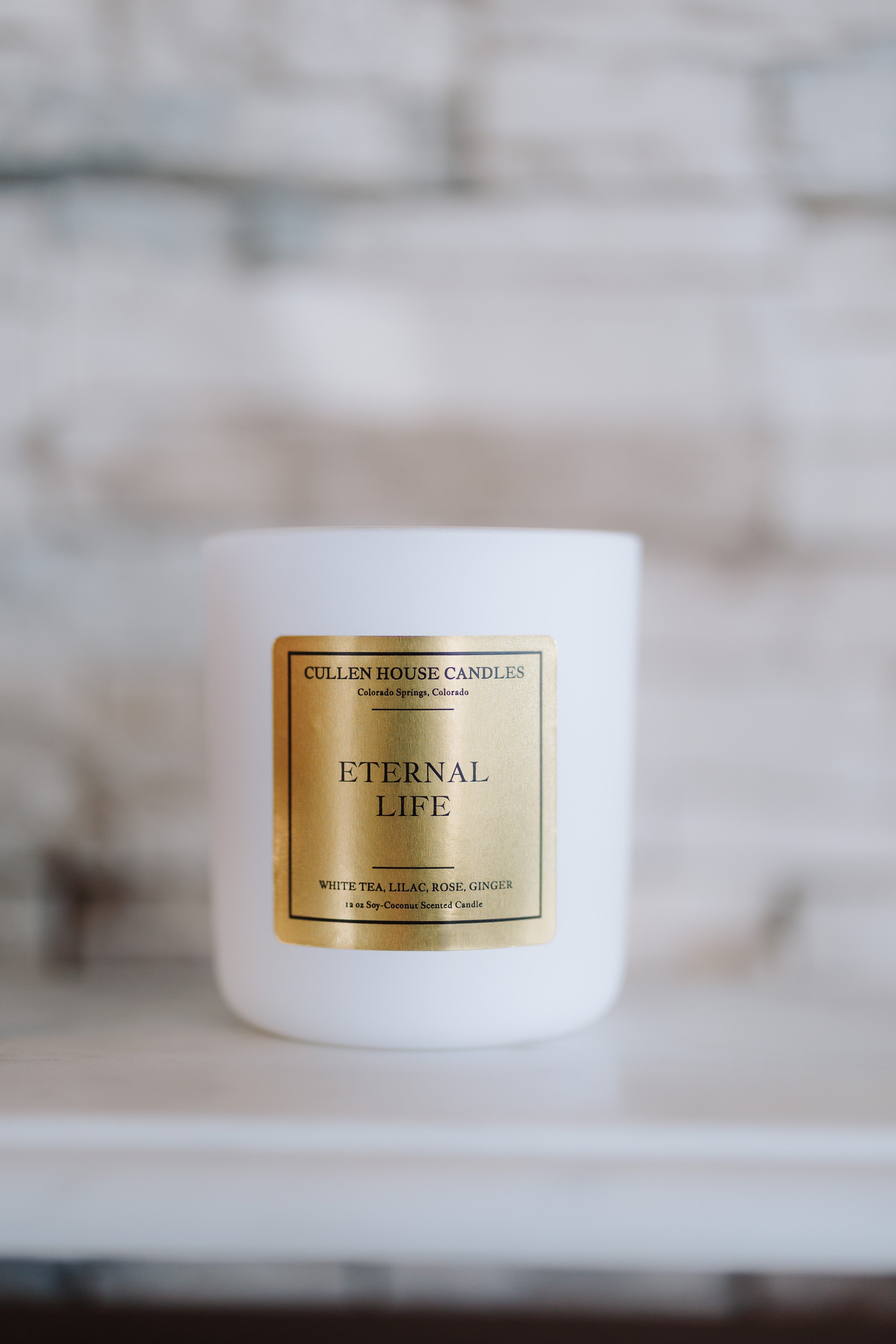 White candle with 'Eternal Life' label on a blurred background