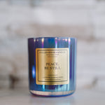 Candle with 'Peace. Be Still' label on a marble surface