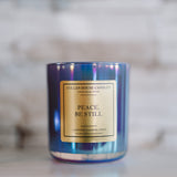 Candle with 'Peace. Be Still' label on a marble surface