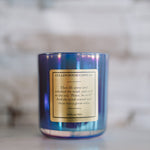 Blue candle with a gold label on a marble surface
