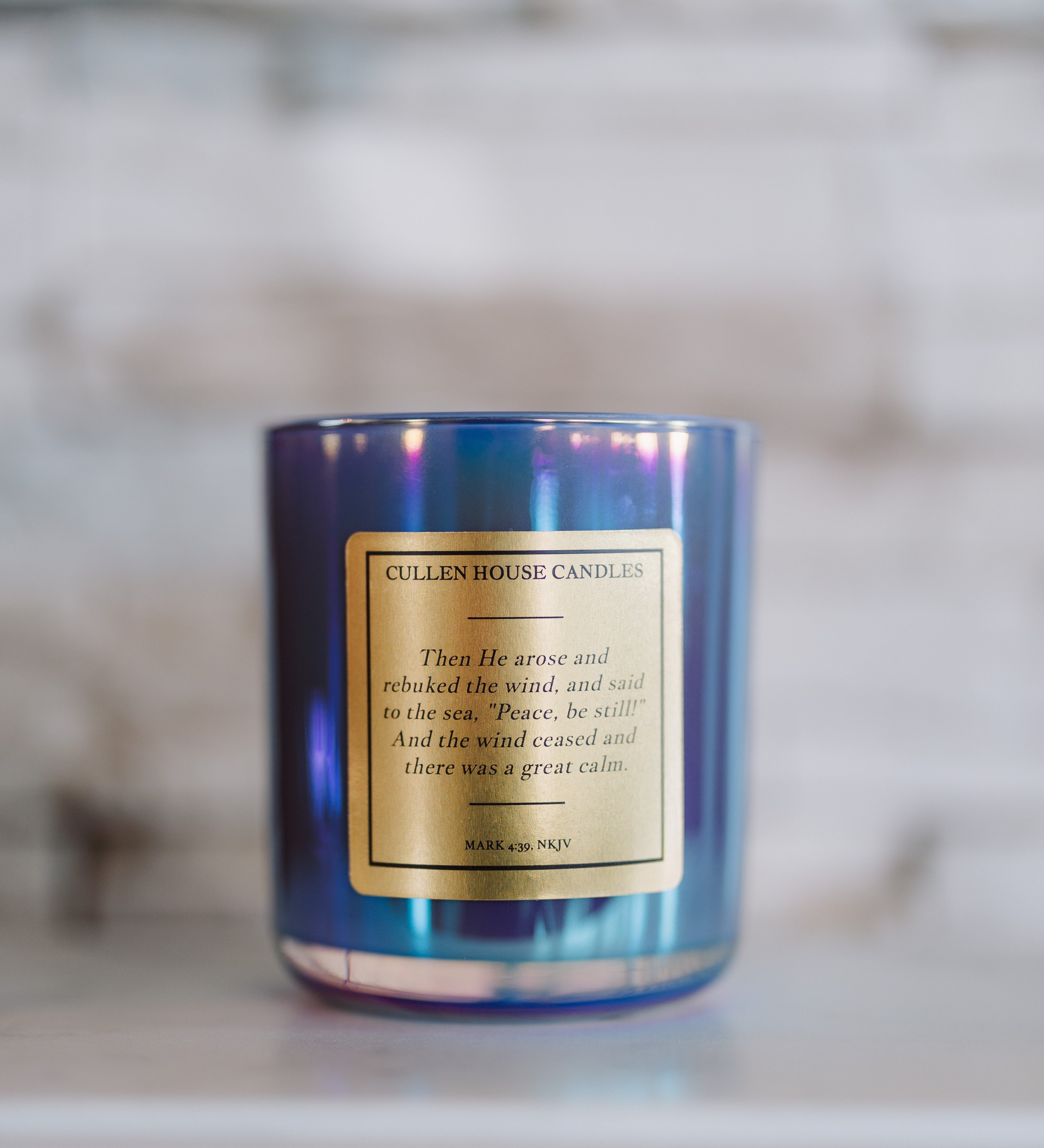 Blue candle with a gold label on a marble surface