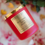Red candle with gold lid labeled 'Seal Upon Your Heart' on a floral background